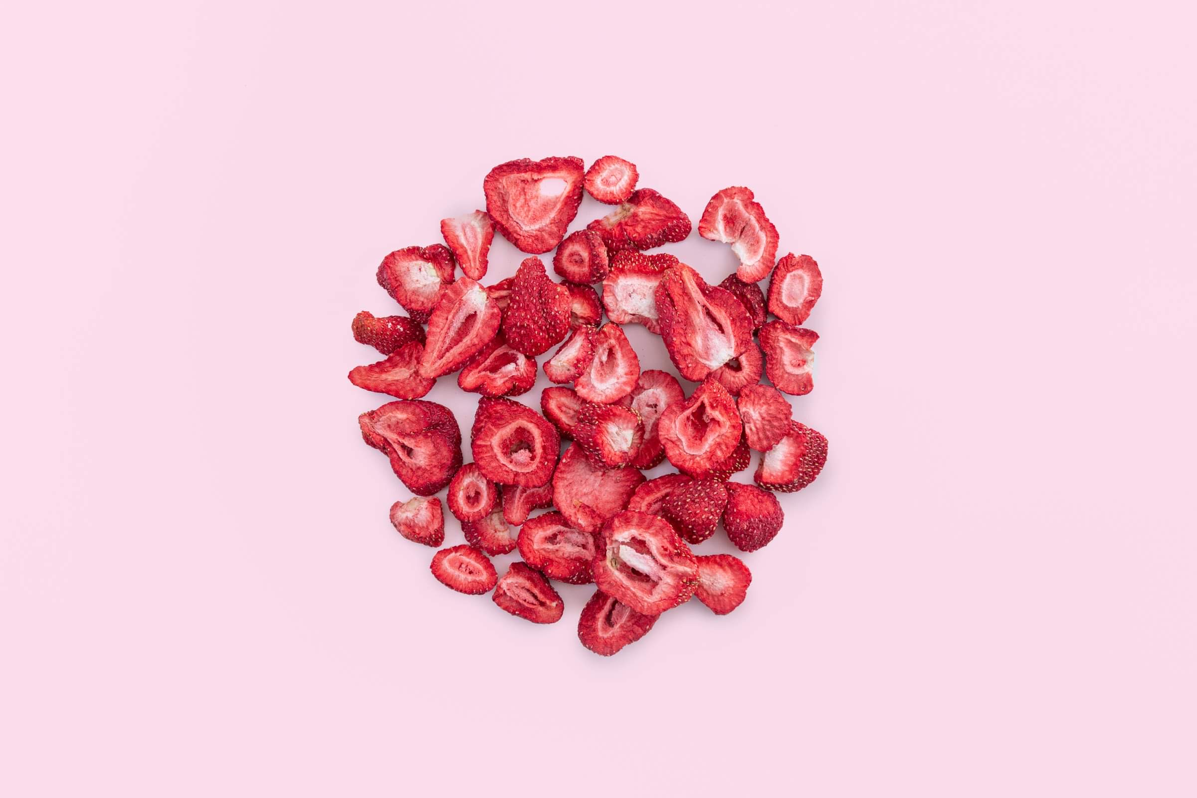 Origo freeze-dried Canadian strawberry slices on a soft pink background