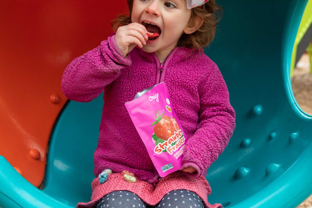 A child eating Origo freeze-dried strawberries straight from the pouch